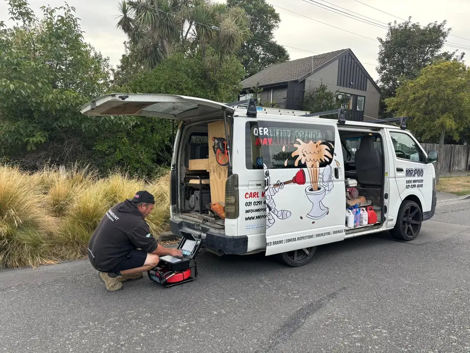 Carl running a CCTV drain camera from the back of the Mr Poo van on a Christchurch street